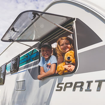 Children looking out of a caravan window