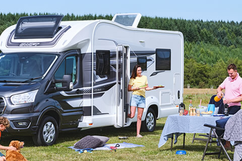 Family enjoying a BBQ outside their motorhome