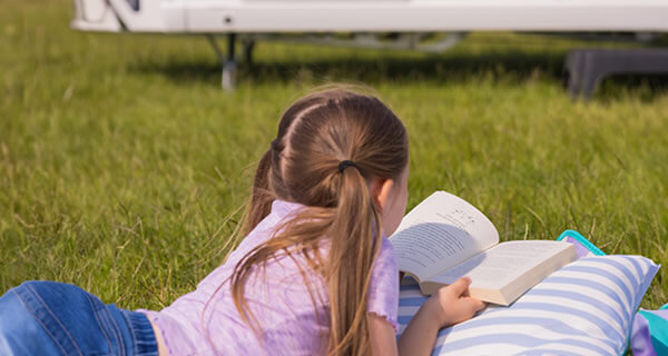 Child reading outside on the grass